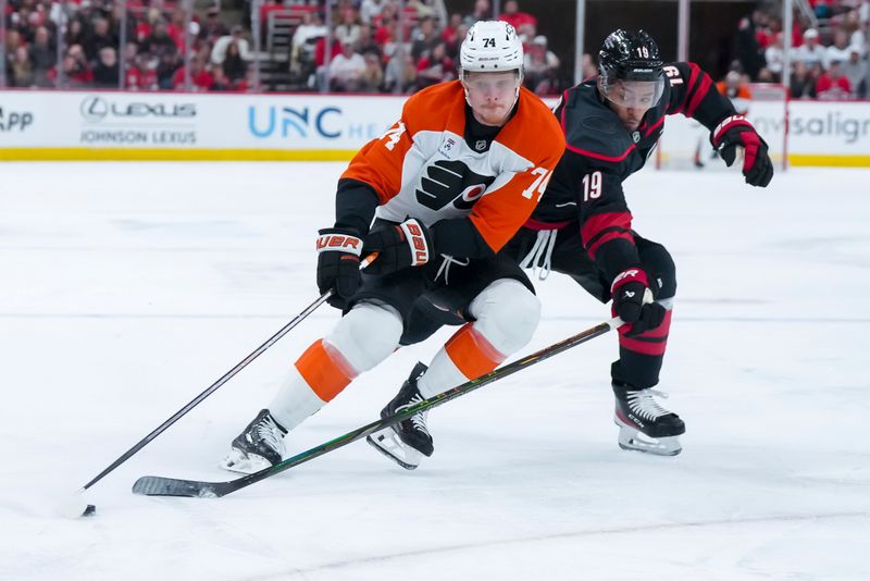 Oct 11, 2025; Raleigh, North Carolina, USA;  Philadelphia Flyers right wing Owen Tippett (74) skates with the puck outside of Carolina Hurricanes defenseman K'Andre Miller (19) during the second period at Lenovo Center. Mandatory Credit: James Guillory-Imagn Images