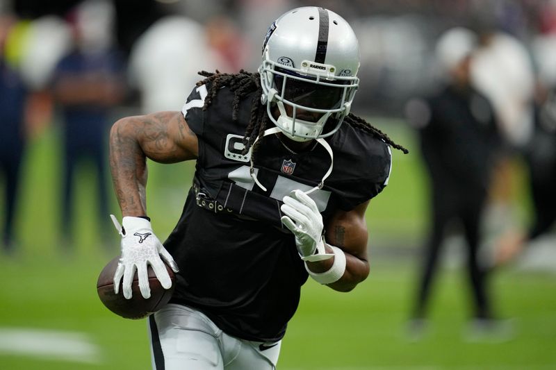 Las Vegas Raiders wide receiver Davante Adams (17) warms up before an NFL football game against the New England Patriots, Sunday, Oct. 15, 2023, in Las Vegas. (AP Photo/John Locher)