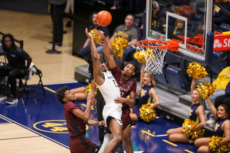 Dec 9, 2025; Morgantown, West Virginia, USA; West Virginia Mountaineers guard Chance Moore (13) and Little Rock Trojans forward Truman Claytor IV (22) collide in the air during the first half at Hope Coliseum. Mandatory Credit: Ben Queen-Imagn Images