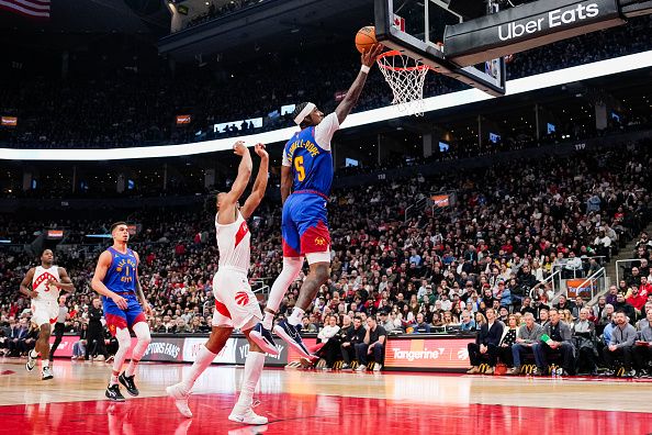 TORONTO, ON - DECEMBER 20: Kentavious Caldwell-Pope #5 of the Denver Nuggets goes to the basket against Scottie Barnes #4 of the Toronto Raptors during the first half at Scotiabank Arena on December 20, 2023 in Toronto, Ontario, Canada. NOTE TO USER: User expressly acknowledges and agrees that, by downloading and/or using this Photograph, user is consenting to the terms and conditions of the Getty Images License Agreement. (Photo by Andrew Lahodynskyj/Getty Images)