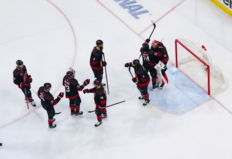 Apr 20, 2024; Raleigh, North Carolina, USA; Carolina Hurricanes players celebrate their victory against the New York Islanders in game one of the first round of the 2024 Stanley Cup Playoffs at PNC Arena. Mandatory Credit: James Guillory-USA TODAY Sports