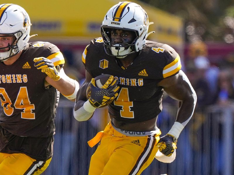 Sep 30, 2023; Laramie, Wyoming, USA; Wyoming Cowboys running back Harrison Waylee (4) runs against the New Mexico Lobos during the first quarter at Jonah Field at War Memorial Stadium. Mandatory Credit: Troy Babbitt-USA TODAY Sports

