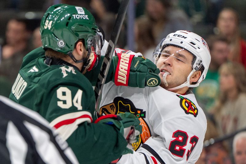 Oct 1, 2024; Saint Paul, Minnesota, USA; Minnesota Wild forward Jake Lauko (94) and Chicago Blackhawks center Philipp Kurashev (23) fight in the first period at Xcel Energy Center. Mandatory Credit: Matt Blewett-Imagn Images