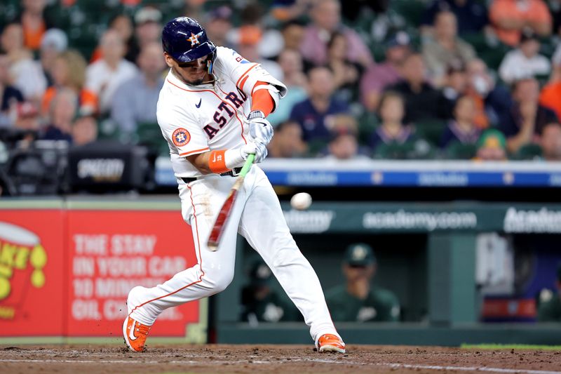 May 28, 2025; Houston, Texas, USA; Houston Astros third baseman Isaac Paredes (15) hits a sacrifice fly to score a run against the Athletics during the third inning at Daikin Park. Mandatory Credit: Erik Williams-Imagn Images
