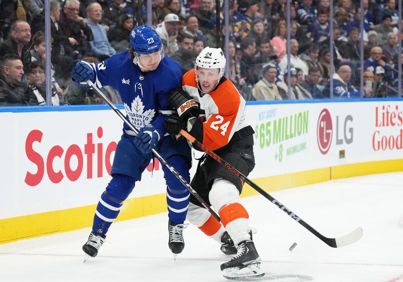 Feb 15, 2024; Toronto, Ontario, CAN; Toronto Maple Leafs left wing Matthew Knies (23) and Philadelphia Flyers defenseman Nick Seeler (24) battle for the puck during the third period at Scotiabank Arena. Mandatory Credit: Nick Turchiaro-USA TODAY Sports