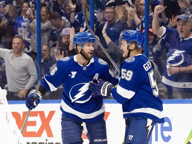 Oct 15, 2024; Tampa, Florida, USA; Tampa Bay Lightning right wing Nikita Kucherov (86) is congratulated by center Jake Guentzel (59) after he scored a goal against the Vancouver Canucks  during the first period at Amalie Arena. Mandatory Credit: Kim Klement Neitzel-Imagn Images