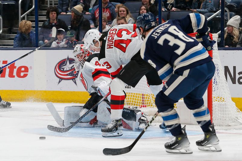 Jan 19, 2024; Columbus, Ohio, USA; New Jersey Devils defenseman Luke Hughes (43) clears the  puck as Columbus Blue Jackets center Boone Jenner (38) trails the play during the first period at Nationwide Arena. Mandatory Credit: Russell LaBounty-USA TODAY Sports