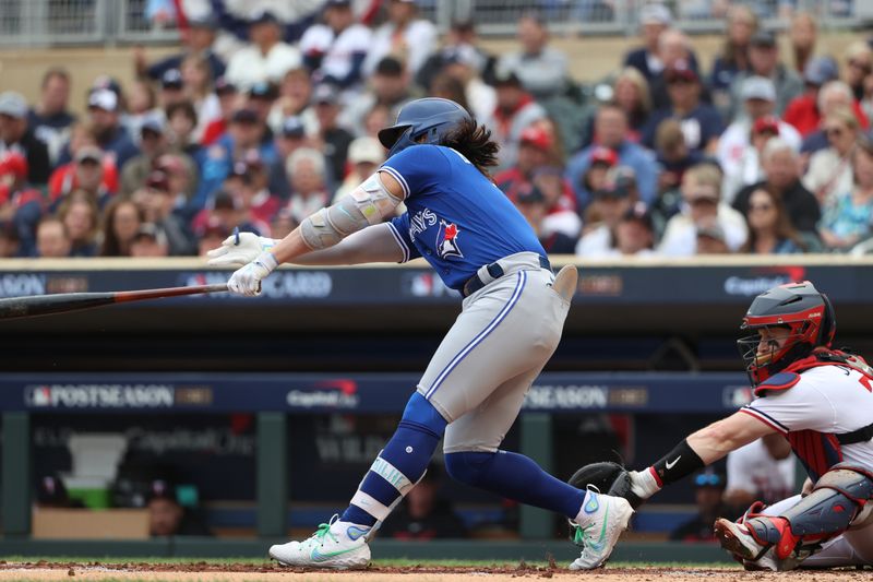 Oct 4, 2023; Minneapolis, Minnesota, USA; Toronto Blue Jays shortstop Bo Bichette (11) hits a single in the third inning against the Minnesota Twins during game two of the Wildcard series for the 2023 MLB playoffs at Target Field. Mandatory Credit: Jesse Johnson-USA TODAY Sports
