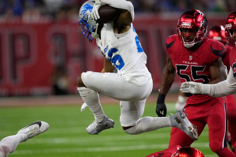 Detroit Lions running back Jahmyr Gibbs (26) runs from Houston Texans defensive end Danielle Hunter (55) during the second half of an NFL football game, Sunday, Nov. 10, 2024, in Houston. (AP Photo/David J. Phillip)