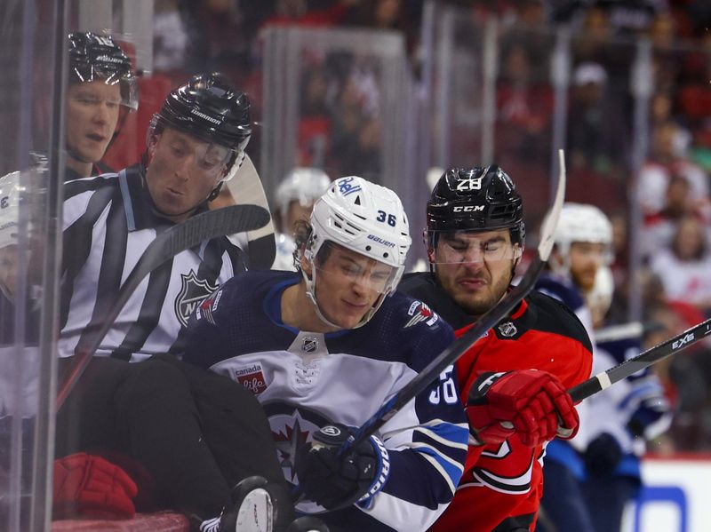 Mar 21, 2024; Newark, New Jersey, USA; New Jersey Devils right wing Timo Meier (28) hits Winnipeg Jets center Morgan Barron (36) during the third period at Prudential Center. Mandatory Credit: Ed Mulholland-USA TODAY Sports