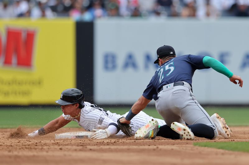 May 23, 2024; Bronx, New York, USA; New York Yankees third baseman Oswaldo Cabrera (95) is tagged out by Seattle Mariners second baseman Dylan Moore (25) while attempting to steal second base during the sixth inning at Yankee Stadium. Mandatory Credit: Brad Penner-USA TODAY Sports