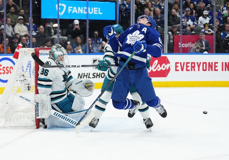 Jan 9, 2024; Toronto, Ontario, CAN; Toronto Maple Leafs right wing Mitchell Marner (16) battles for the puck in front of San Jose Sharks goaltender Kaapo Kahkonen (36) during the first period at Scotiabank Arena. Mandatory Credit: Nick Turchiaro-USA TODAY Sports