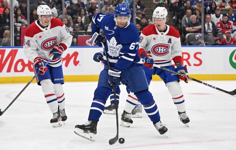 Sep 26, 2024; Toronto, Ontario, CAN;  Toronto Maple Leafs forward Max Pacioretty (67) deflects a shot as Montreal Canadiens defenseman David Reinbacher (64) and forward Christian Dvorak (28) look on in the first period at Scotiabank Arena. Mandatory Credit: Dan Hamilton-Imagn Images