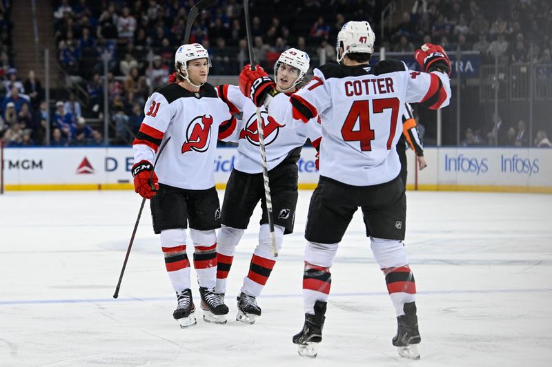 Dec 2, 2024; New York, New York, USA;  New Jersey Devils center Dawson Mercer (91) celebrates his goal with center Paul Cotter (47) and defenseman Luke Hughes (43) in the first period against the New York Rangers at Madison Square Garden. Mandatory Credit: Dennis Schneidler-Imagn Images