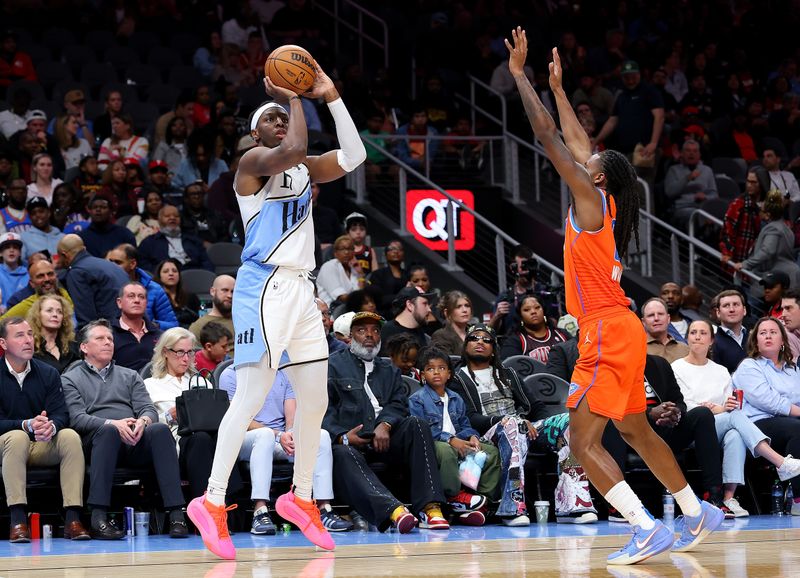 ATLANTA, GEORGIA - FEBRUARY 28:  Onyeka Okongwu #17 of the Atlanta Hawks shoots a three-point basket against Cason Wallace #22 of the Oklahoma City Thunder during the fourth quarter at State Farm Arena on February 28, 2025 in Atlanta, Georgia.  NOTE TO USER: User expressly acknowledges and agrees that, by downloading and or using this photograph, User is consenting to the terms and conditions of the Getty Images License Agreement.  (Photo by Kevin C. Cox/Getty Images)