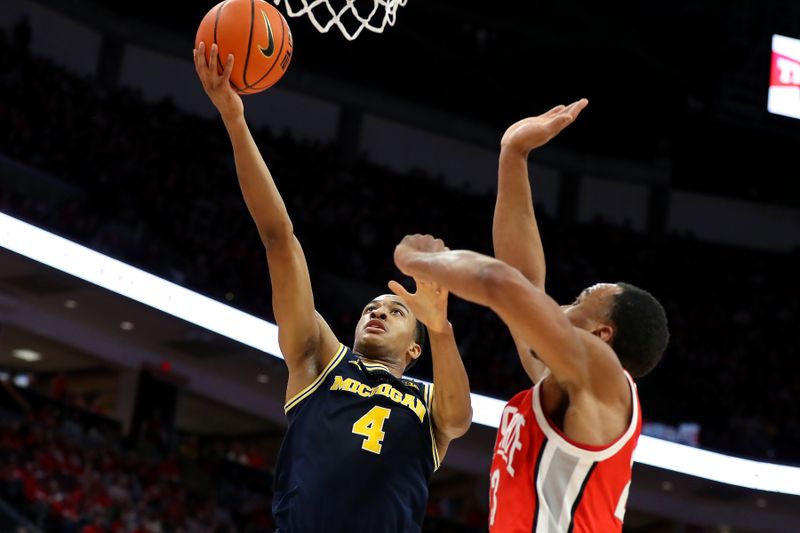 Mar 3, 2024; Columbus, Ohio, USA; Michigan Wolverines guard Nimari Burnett (4) dscores on the layup as Ohio State Buckeyes forward Zed Key (23) defends during the first half at Value City Arena. Mandatory Credit: Joseph Maiorana-USA TODAY Sports