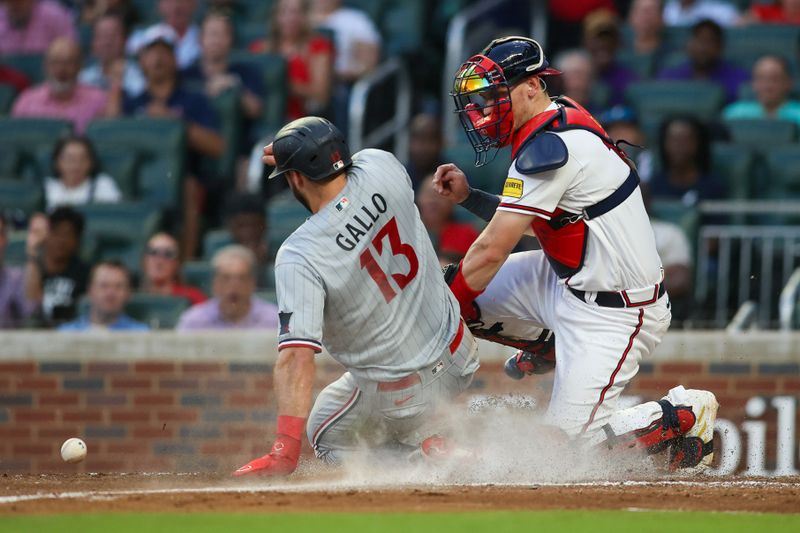 Jun 27, 2023; Atlanta, Georgia, USA; Minnesota Twins left fielder Joey Gallo (13) slides safely past the tag of Atlanta Braves catcher Sean Murphy (12) in the fourth inning at Truist Park. Mandatory Credit: Brett Davis-USA TODAY Sports