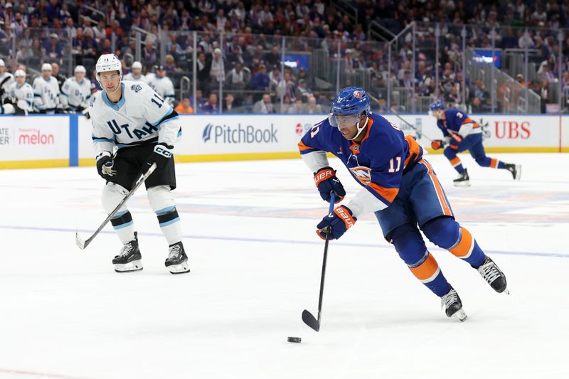 Oct 10, 2024; Elmont, New York, USA; New York Islanders left wing Anthony Duclair (11) skates with the puck against Utah Hockey Club right wing Dylan Guenther (11) during overtime at UBS Arena. Mandatory Credit: Brad Penner-Imagn Images