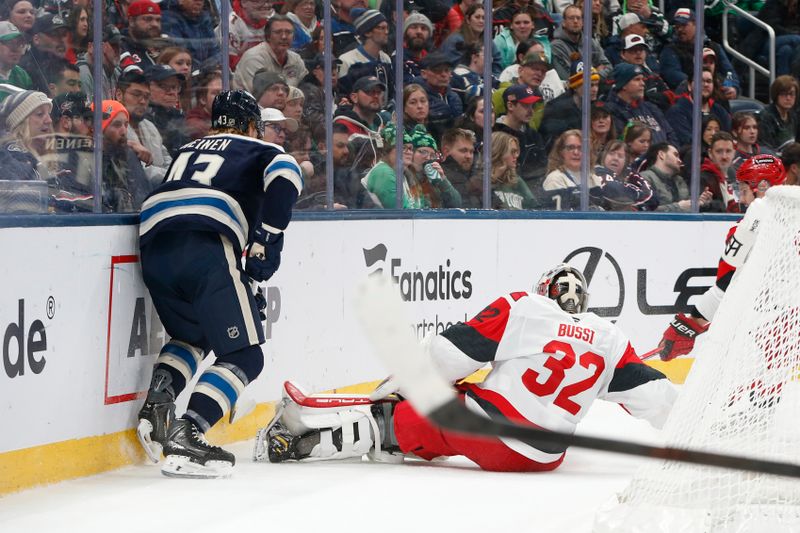 Mar 17, 2026; Columbus, Ohio, USA; Carolina Hurricanes goalie Brandon Bussi (32) falls to the ice after a collision with Columbus Blue Jackets defenseman Danton Heinen (43) during the second period at Nationwide Arena. Mandatory Credit: Russell LaBounty-Imagn Images