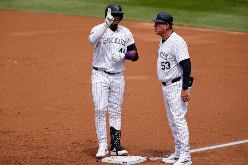 Apr 10, 2024; Denver, Colorado, USA; Colorado Rockies first baseman Elehuris Montero (44) reacts from first next to first base coach Ronnie Gideon (53) after hitting an RBI single in the first inning against the Arizona Diamondbacks at Coors Field. Mandatory Credit: Isaiah J. Downing-USA TODAY Sports