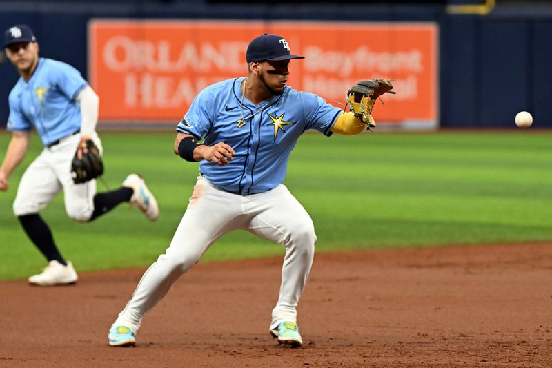 Jul 28, 2024; St. Petersburg, Florida, USA; Tampa Bay Rays third baseman Isaac Paredes (17) fields a ground ball in the first inning against the Cincinnati Reds  at Tropicana Field. Mandatory Credit: Jonathan Dyer-USA TODAY Sports