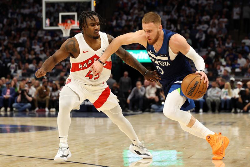 MINNEAPOLIS, MINNESOTA - OCTOBER 26: Donte DiVincenzo #0 of the Minnesota Timberwolves drives to the basket against Davion Mitchell #45 of the Toronto Raptors in the second quarter of the home opener at Target Center on October 26, 2024 in Minneapolis, Minnesota. The Timberwolves defeated the Raptors 112-101. NOTE TO USER: User expressly acknowledges and agrees that, by downloading and or using this photograph, User is consenting to the terms and conditions of the Getty Images License Agreement. (Photo by David Berding/Getty Images)