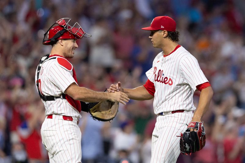 Jul 27, 2024; Philadelphia, Pennsylvania, USA;  Philadelphia Phillies pitcher Tyler Phillips (48) and catcher J.T. Realmuto (10) shake hands after a victory against the Cleveland Guardians at Citizens Bank Park. Mandatory Credit: Bill Streicher-USA TODAY Sports