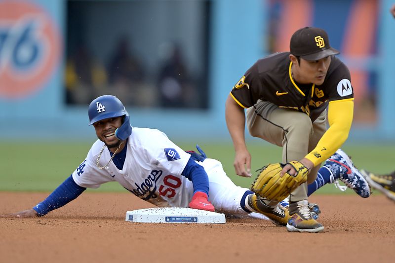 Apr 14, 2024; Los Angeles, California, USA; Los Angeles Dodgers shortstop Mookie Betts (50) beats the throw to San Diego Padres shortstop Ha-Seong Kim (7) for a stolen base in the first inning at Dodger Stadium. Mandatory Credit: Jayne Kamin-Oncea-USA TODAY Sports