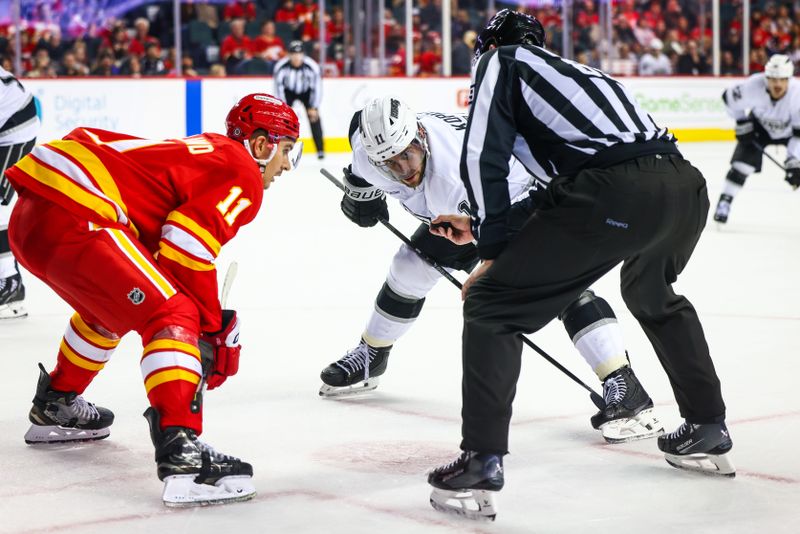 Nov 11, 2024; Calgary, Alberta, CAN; Los Angeles Kings center Anze Kopitar (11) and Calgary Flames center Mikael Backlund (11) face off for the puck during the third period at Scotiabank Saddledome. Mandatory Credit: Sergei Belski-Imagn Images