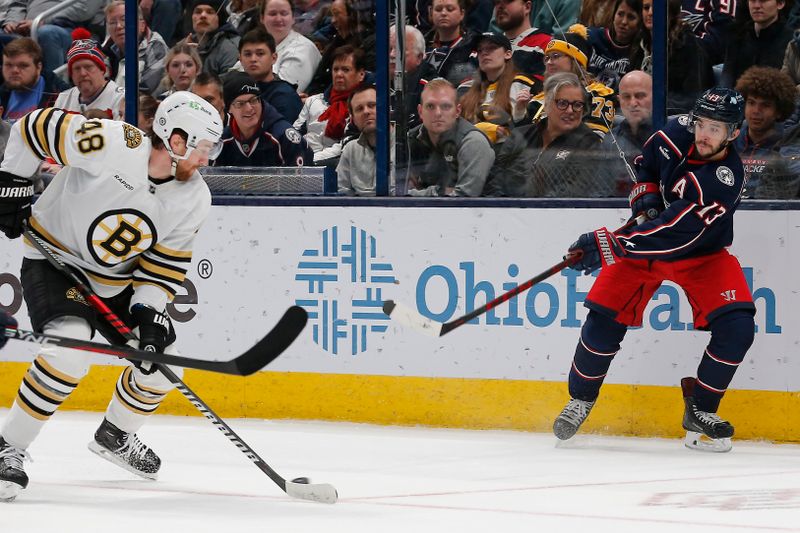 Jan 2, 2024; Columbus, Ohio, USA; Columbus Blue Jackets left wing Johnny Gaudreau (13) passes the puck under the stick of Boston Bruins defenseman Matt Grzelcyk (48) during the first period at Nationwide Arena. Mandatory Credit: Russell LaBounty-USA TODAY Sports