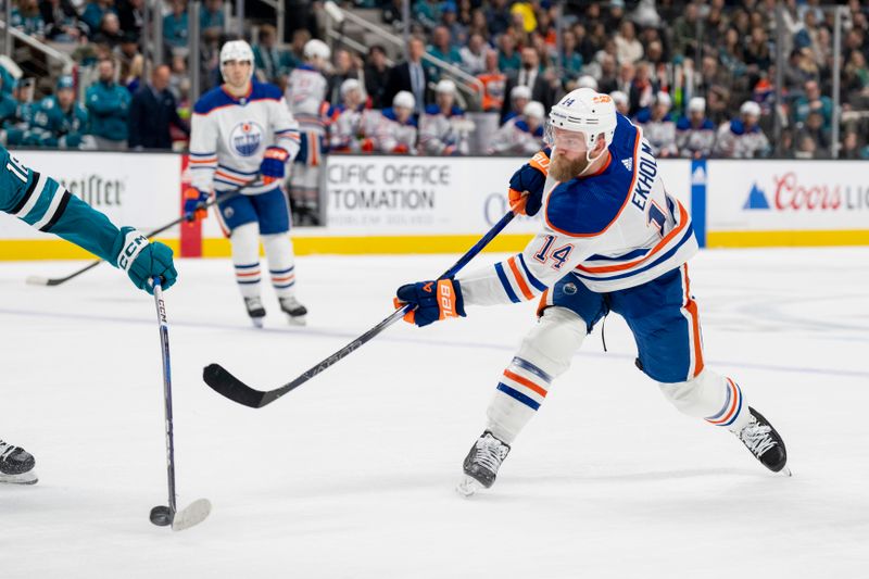 Dec 28, 2023; San Jose, California, USA; Edmonton Oilers defenseman Mattias Ekholm (14) shoots the puck against the San Jose Sharks during the first period at SAP Center at San Jose. Mandatory Credit: Neville E. Guard-USA TODAY Sports