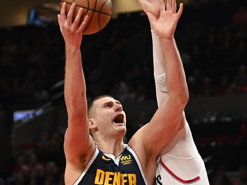 PORTLAND, OREGON - OCTOBER 24: Nikola Jokic #15 of the Denver Nuggets drives to the basket against Jusuf Nurkic #27 of the Portland Trail Blazers during the fourth quarter at Moda Center on October 24, 2022 in Portland, Oregon. The Portland Trail Blazers won 135-110. NOTE TO USER: User expressly acknowledges and agrees that, by downloading and or using this photograph, User is consenting to the terms and conditions of the Getty Images License Agreement. (Photo by Alika Jenner/Getty Images)