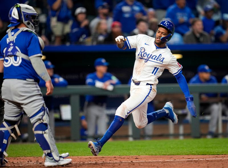 Apr 23, 2024; Kansas City, Missouri, USA; Kansas City Royals third base Maikel Garcia (11) scored a run against Toronto Blue Jays catcher Alejandro Kirk (30) during the fifth inning at Kauffman Stadium. Mandatory Credit: Jay Biggerstaff-USA TODAY Sports