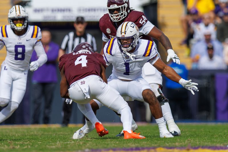 Nov 25, 2023; Baton Rouge, Louisiana, USA; Texas A&M Aggies running back Amari Daniels (4) is tacked by LSU Tigers linebacker Omar Speights (1) during the first half at Tiger Stadium. Mandatory Credit: Stephen Lew-USA TODAY Sports