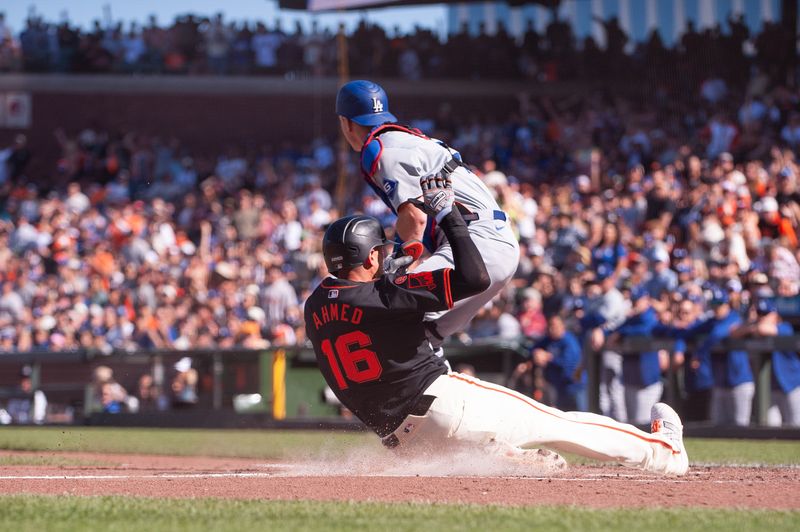 Jun 29, 2024; San Francisco, California, USA; San Francisco Giants shortstop Nick Ahmed (16) slides into home plate during the third inning against the Los Angeles Dodgers at Oracle Park. Mandatory Credit: Ed Szczepanski-USA TODAY Sports