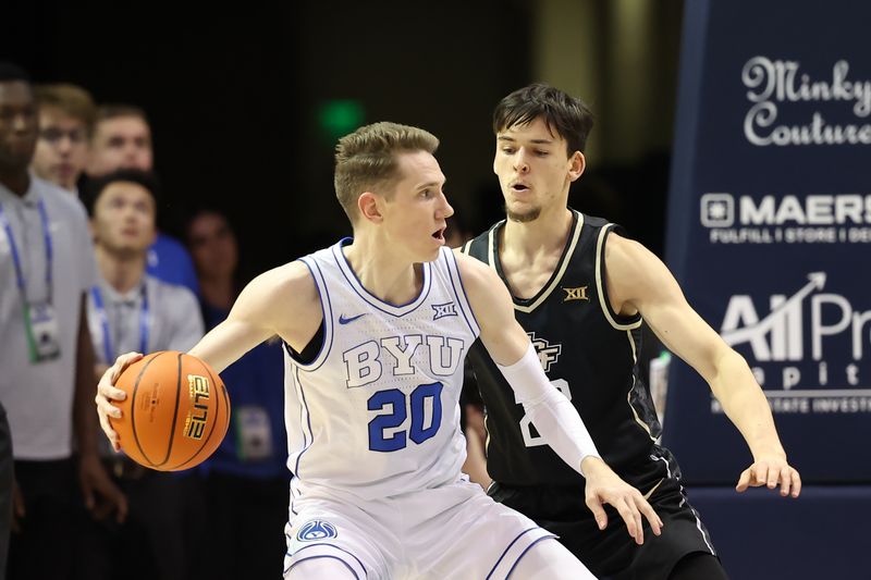 Feb 13, 2024; Provo, Utah, USA; Brigham Young Cougars guard Spencer Johnson (20) looks to pass the ball against Central Florida Knights guard Nils Machowski (22) during the first half at Marriott Center. Mandatory Credit: Rob Gray-USA TODAY Sports