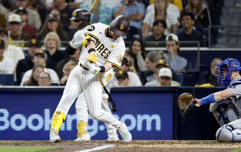 Oct 9, 2024; San Diego, California, USA; San Diego Padres first baseman Jake Cronenworth (9) triples in the seventh inning against the Los Angeles Dodgers during game four of the NLDS for the 2024 MLB Playoffs at Petco Park. Mandatory Credit: David Frerker-Imagn Images