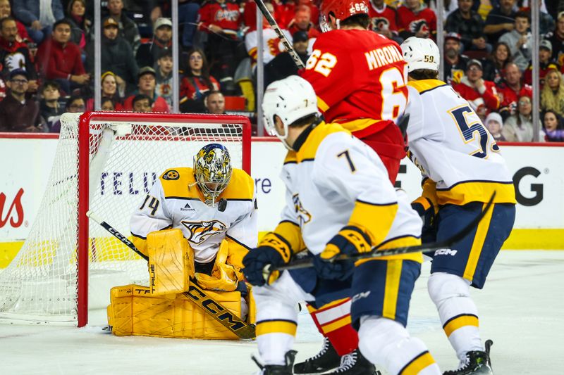 Nov 15, 2024; Calgary, Alberta, CAN; Nashville Predators goaltender Juuse Saros (74) makes a save against Calgary Flames defenseman Daniil Miromanov (62) during the second period at Scotiabank Saddledome. Mandatory Credit: Sergei Belski-Imagn Images