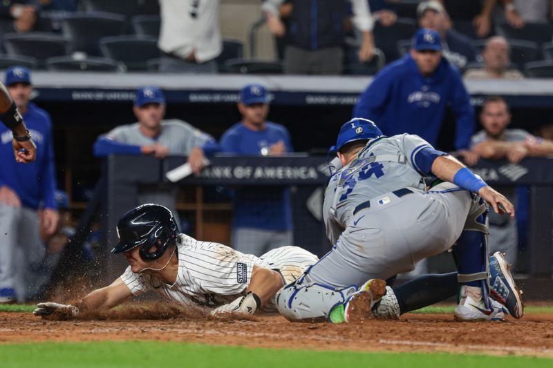 Sep 11, 2024; Bronx, New York, USA; New York Yankees shortstop Anthony Volpe (11) scores as Kansas City Royals catcher Freddy Fermin (34) can not handle the throw during the tenth inning  at Yankee Stadium. Mandatory Credit: Vincent Carchietta-Imagn Images