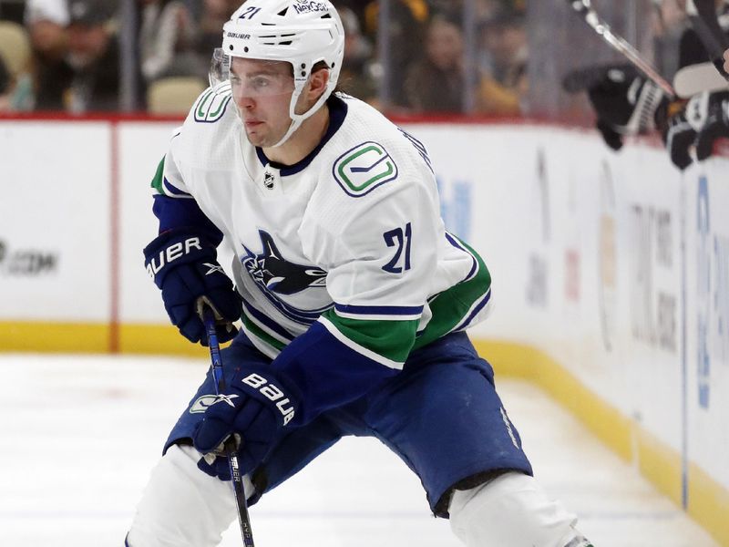 Jan 11, 2024; Pittsburgh, Pennsylvania, USA; Vancouver Canucks left wing Nils Hoglander (21) skates with the puck against the Pittsburgh Penguins during the second period at PPG Paints Arena. Mandatory Credit: Charles LeClaire-USA TODAY Sports