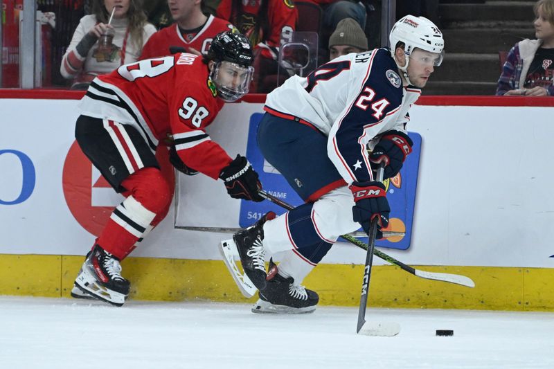 Mar 2, 2024; Chicago, Illinois, USA;   and Columbus Blue Jackets right wing Mathieu Olivier (24) chase the puck Chicago Blackhawks center Connor Bedard (98)during the first period at the  United Center. Mandatory Credit: Matt Marton-USA TODAY Sports