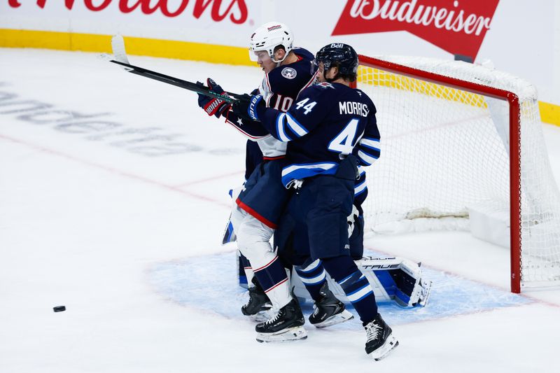Nov 18, 2025; Winnipeg, Manitoba, CAN;  Winnipeg Jets defenseman Josh Morrissey (44) jostles for position with Columbus Blue Jackets forward Dmitri Voronkov (10) during the third period at Canada Life Centre. Mandatory Credit: Terrence Lee-Imagn Images