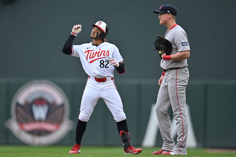 May 4, 2024; Minneapolis, Minnesota, USA; Minnesota Twins centerfielder Austin Martin (82) reacts after hitting a single as Boston Red Sox first base Garrett Cooper (28) looks on during the fifth inning at Target Field. Mandatory Credit: Jeffrey Becker-USA TODAY Sports