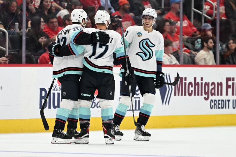 Oct 24, 2023; Detroit, Michigan, USA; Seattle Kraken center Jaden Schwartz (17) celebrates with teammates right wing Oliver Bjorkstrand (22) and center Alex Wennberg (21) after scoring a goal against the Detroit Red Wings  in the second period at Little Caesars Arena. Mandatory Credit: Lon Horwedel-USA TODAY Sports