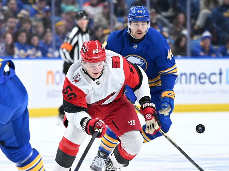 Nov 23, 2025; Buffalo, New York, USA; Carolina Hurricanes left wing Eric Robinson (50)chases the puck in front of Buffalo Sabres center Josh Dunne (44) in the first period at KeyBank Center. Mandatory Credit: Mark Konezny-Imagn Images