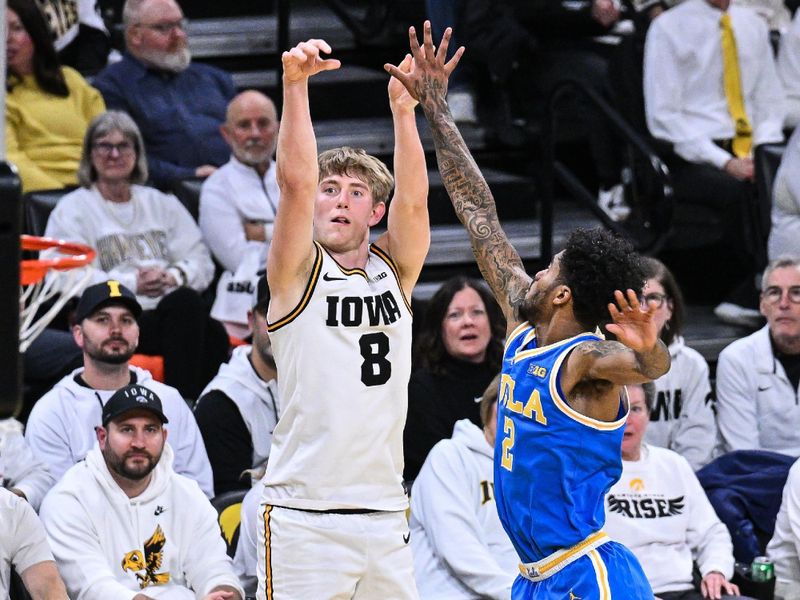Jan 3, 2026; Iowa City, Iowa, USA; Iowa Hawkeyes forward Cooper Koch (8) shoots a three-point basket as UCLA Bruins guard Donovan Dent (2) defends during the second half at Carver-Hawkeye Arena. Mandatory Credit: Jeffrey Becker-Imagn Images