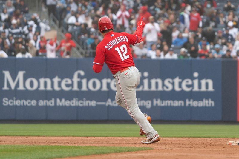 Apr 5, 2023; Bronx, New York, USA; Philadelphia Phillies left fielder Kyle Schwarber (12) reacts to hitting a home run against the New York Yankees during the eighth inning at Yankee Stadium. Mandatory Credit: Gregory Fisher-USA TODAY Sports