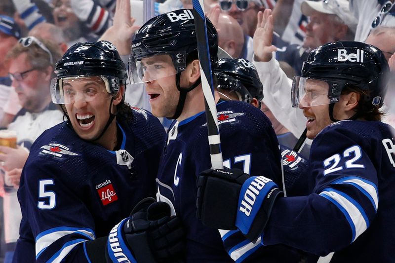 Apr 21, 2024; Winnipeg, Manitoba, CAN; Winnipeg Jets center Adam Lowry (17) celebrates his second period goal with Winnipeg Jets defenseman Brenden Dillon (5) and Winnipeg Jets center Mason Appleton (22) against the Colorado Avalanche in game one of the first round of the 2024 Stanley Cup Playoffs at Canada Life Centre. Mandatory Credit: James Carey Lauder-USA TODAY Sports