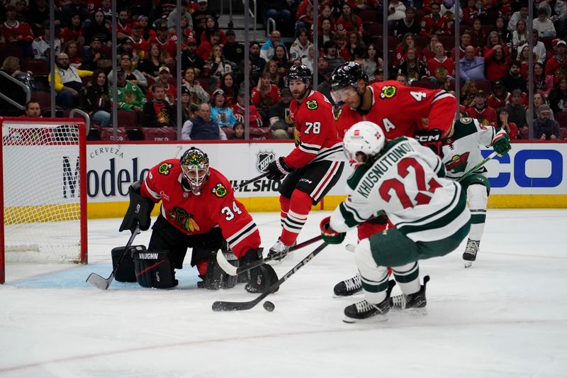 Oct 4, 2024; Chicago, Illinois, USA; Chicago Blackhawks defenseman Seth Jones (4) and goaltender Petr Mrazek (34) defend Minnesota Wild center Marat Khusnutdinov (22) during the second period at United Center. Mandatory Credit: David Banks-Imagn Images