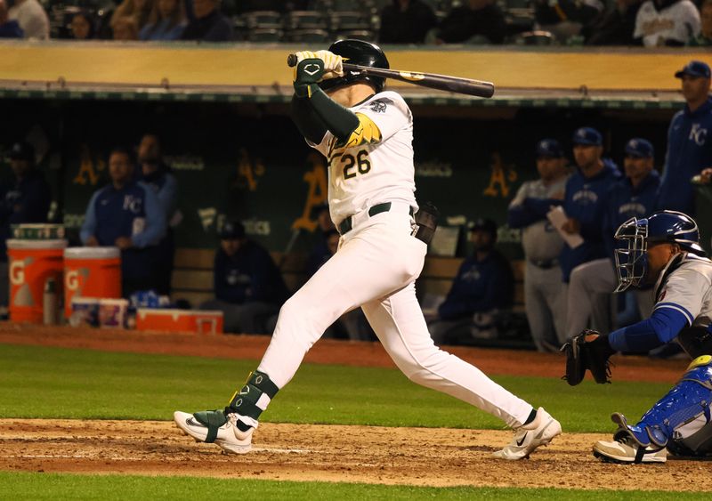 Jun 19, 2024; Oakland, California, USA; Oakland Athletics third baseman Tyler Nevin (26) hits an RBI single against the Kansas City Royals during the seventh inning at Oakland-Alameda County Coliseum. Mandatory Credit: Kelley L Cox-USA TODAY Sports